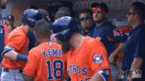 A Group Of Baseball Players Wearing Orange Jerseys With The Number 18 On Them GIF
