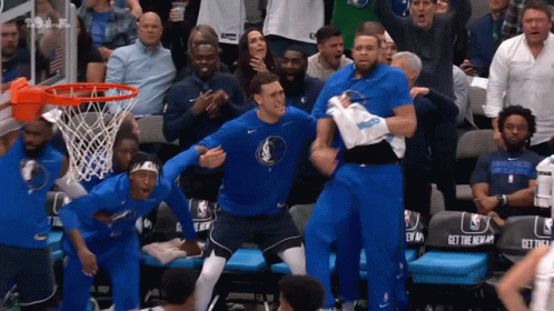 A Group Of Basketball Players Are Celebrating In Front Of A Crowd With A Seat That Says Get The New GIF
