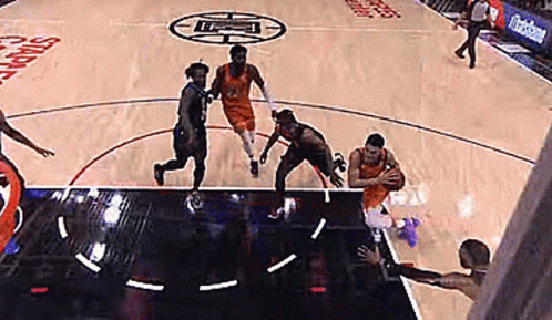 A Group Of Basketball Players Are Playing A Game Of Basketball On A Court With A Logo On The Floor . GIF