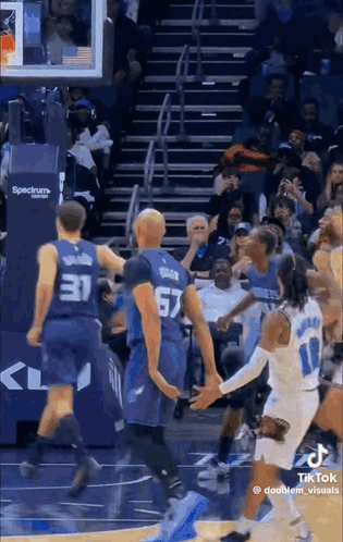A Group Of Basketball Players Are Playing A Game On A Court . GIF