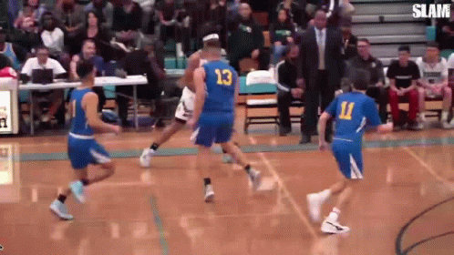 A Group Of Basketball Players Are Playing A Game On A Court With A Crowd Watching . GIF