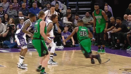 A Group Of Basketball Players Are Playing A Game On A Court With A Crowd Watching . GIF