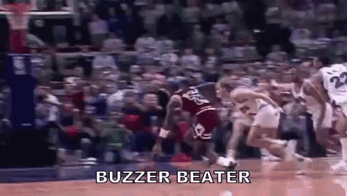 A Group Of Basketball Players Are Playing Basketball On A Court With The Words `` Buzzer Beater '' Written On It . GIF
