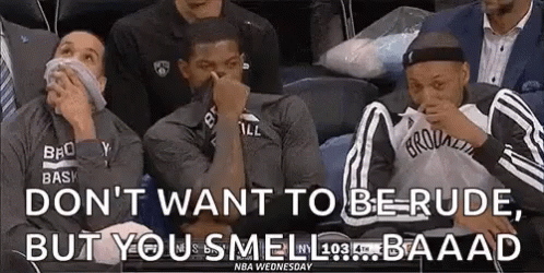 A Group Of Basketball Players Are Sitting In A Stadium Covering Their Noses . GIF