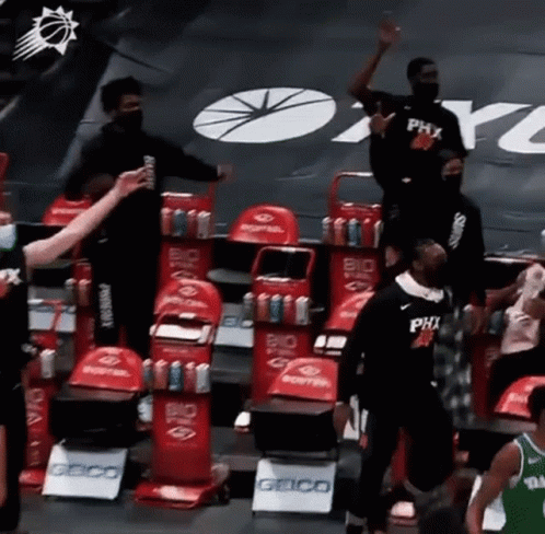 A Group Of Basketball Players Are Standing In A Stadium . GIF
