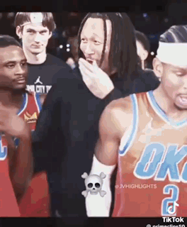 A Group Of Basketball Players Are Standing Next To Each Other And One Of Them Is Covering His Mouth . GIF