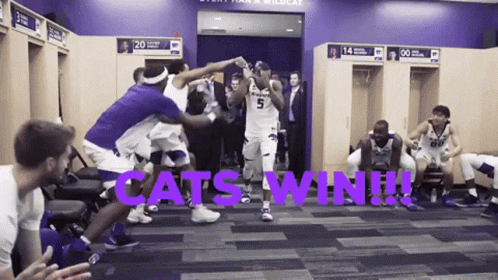 A Group Of Basketball Players In A Locker Room With The Words " Cats Win " On The Floor GIF