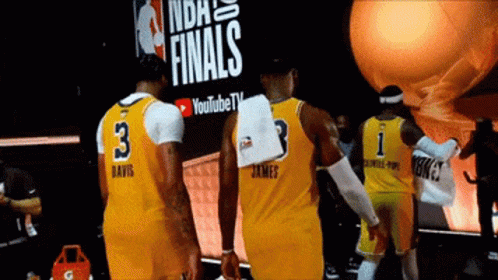 A Group Of Basketball Players Standing In Front Of A Sign That Says Finals GIF