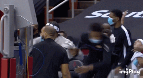 A Group Of Basketball Players Wearing Face Masks Are Standing In A Stadium GIF