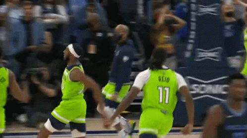 A Group Of Basketball Players Wearing Green Uniforms Are Playing A Game . GIF