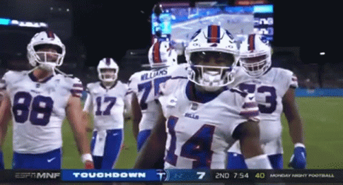 A Group Of Buffalo Bills Football Players Are Standing On The Field GIF