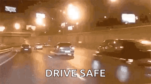 A Group Of Cars Are Driving Down A Highway At Night And The Words `` Drive Safe '' Are Visible . GIF