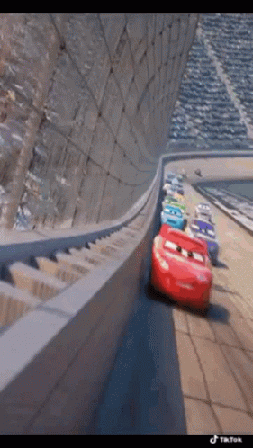A Group Of Cars Are Driving Down A Race Track . GIF