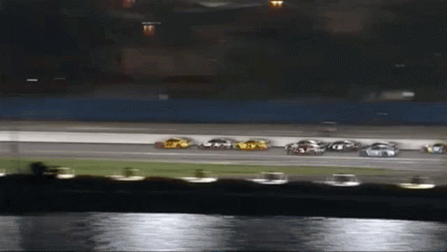 A Group Of Cars Are Racing On A Race Track GIF