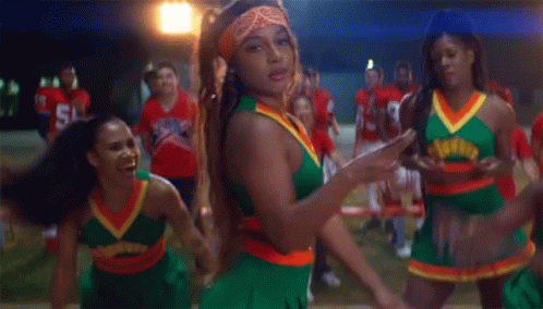 A Group Of Cheerleaders Are Dancing In Front Of A Group Of Football Players One Of Whom Is Wearing Number 38 GIF