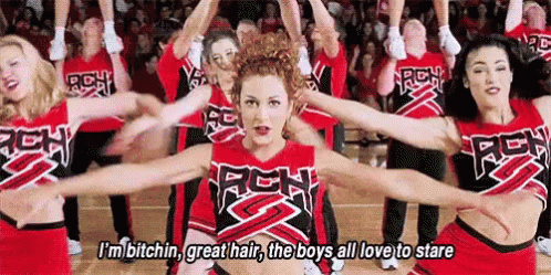 A Group Of Cheerleaders Are Dancing On A Basketball Court With Their Arms Outstretched In Front Of A Crowd . GIF