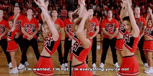 A Group Of Cheerleaders Are Performing On A Basketball Court And One Cheerleader Is Saying I 'M Wanted GIF