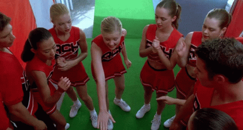 A Group Of Cheerleaders Wearing Red Uniforms With The Letters Rch On Them Are Standing In A Circle GIF