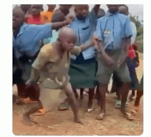 A Group Of Children Are Dancing In The Dirt In Front Of A Crowd . GIF