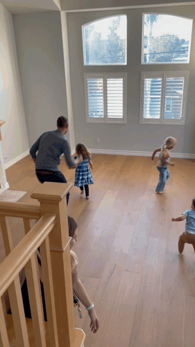A Group Of Children Are Playing In An Empty Room With Shutters On The Windows GIF