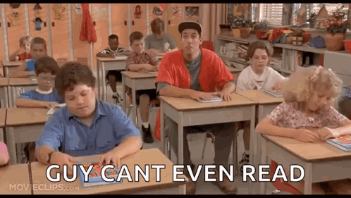 A Group Of Children Are Sitting At Desks In A Classroom With A Man Standing In The Middle Of The Room . GIF