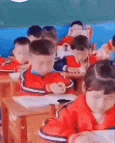 A Group Of Children Are Sitting In A Classroom . GIF