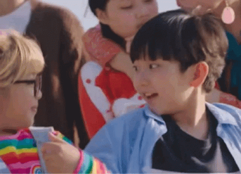 A Group Of Children Are Sitting In A Stadium Watching A Game . GIF
