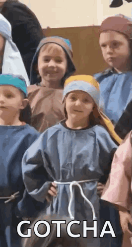 A Group Of Children Dressed In Costumes Are Standing Next To Each Other And One Of Them Is Wearing A Blue Robe . GIF