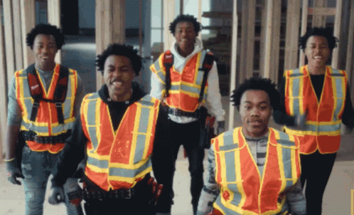 a group of construction workers wearing orange vests are standing together