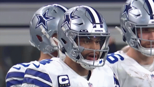 A Group Of Cowboys Players Standing In A Huddle GIF
