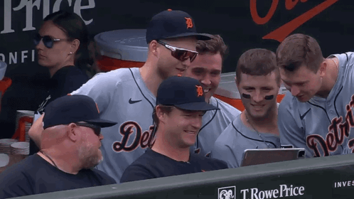 A Group Of Detroit Tigers Players Are Sitting In The Dugout Looking At A Tablet GIF