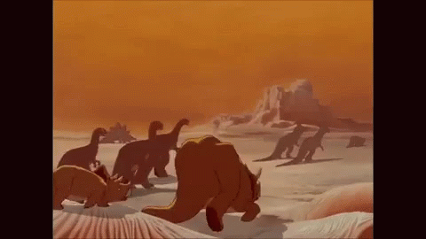 a group of dinosaurs are walking across a desert landscape .