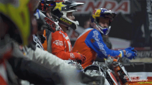 A Group Of Dirt Bike Riders Are Sitting In A Row With One Wearing A Helmet That Says Rockstar On It GIF