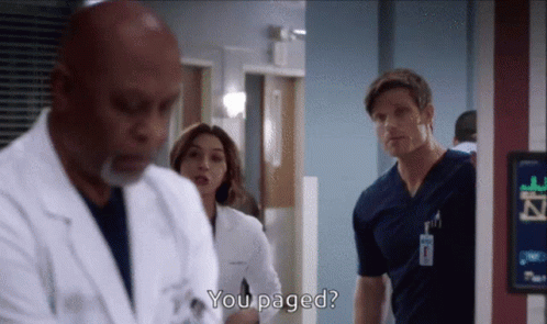 a group of doctors are standing in a hospital hallway and one of them is asking another doctor if he 's paged
