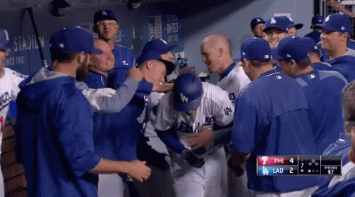 A Group Of Dodgers Baseball Players Are Gathered In The Dugout GIF