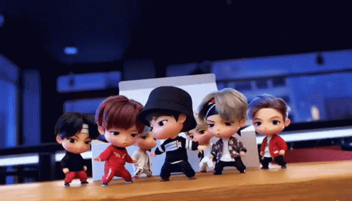 A Group Of Dolls Are Dancing Together On A Table GIF