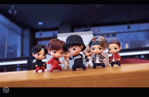 A Group Of Dolls Are Standing On A Table And One Of Them Is Wearing A Hat GIF