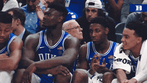 A Group Of Duke Basketball Players Are Sitting In The Stands GIF
