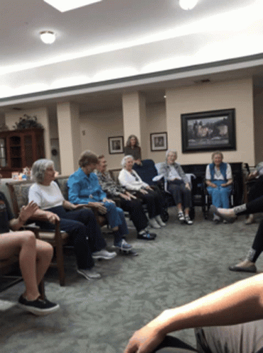 A Group Of Elderly People Are Sitting In A Circle GIF