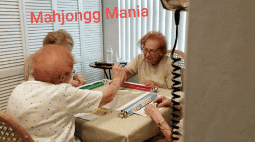 A Group Of Elderly Women Are Playing Mahjongg With The Words Mahjongg Mania Written Above Them GIF