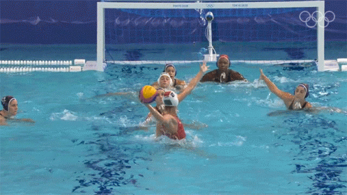 a group of female water polo players are playing a game