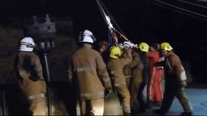 A Group Of Firefighters Wearing Yellow Helmets Are Standing In A Line GIF