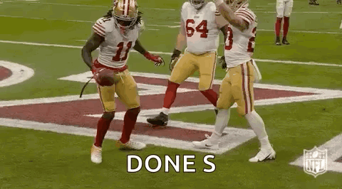 A Group Of Football Players Are Celebrating A Touchdown On A Football Field . GIF