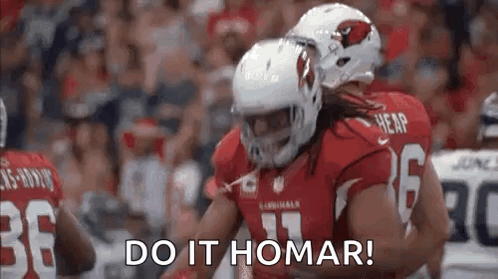 A Group Of Football Players Are Hugging Each Other On A Field . GIF