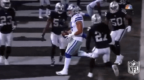 A Group Of Football Players Are Playing A Game Of Football . GIF