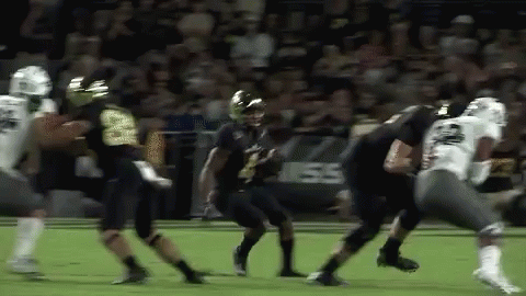 A Group Of Football Players Are Playing A Game Of Football . GIF