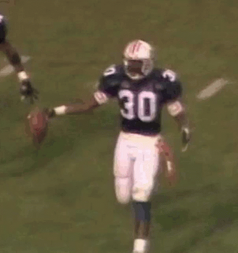 A Group Of Football Players Are Playing A Game Of Football . GIF