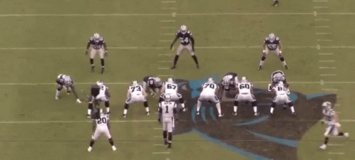 A Group Of Football Players Are Playing A Game On A Field With A Referee In The Middle . GIF