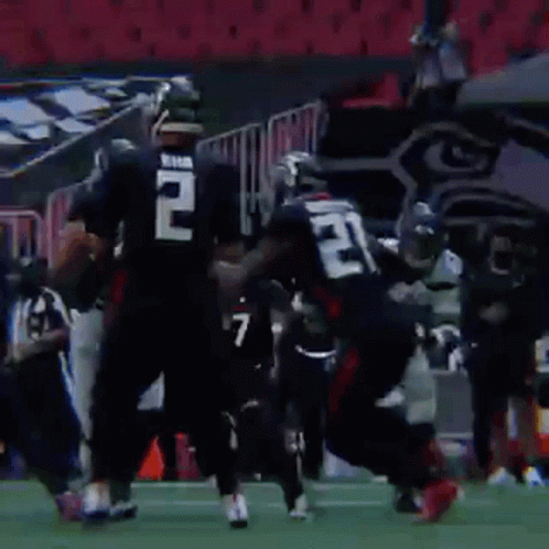 A Group Of Football Players Are Running On A Field With A Sign That Says 40 In The Background . GIF