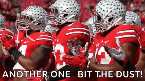 A Group Of Football Players Are Standing In A Line With The Words `` Another One Bit The Dust '' Written Above Them . GIF